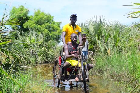 31 yrs old Ayuen Kuol ater on wheelchair, with disability inclusion facilitator Daniel Anyang. In bor flood affected area  